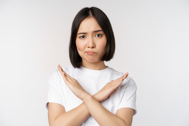 女性が胸の前で両手を交差させている画像